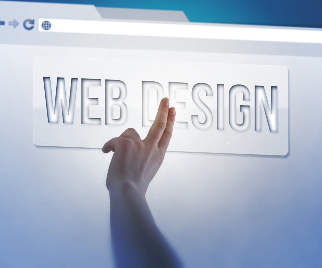 Image of a hand pointing to a desktop screen that says web design